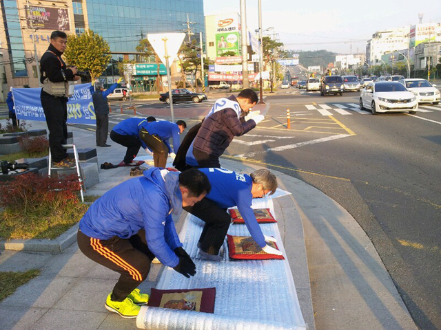 ▲ 민주당 허대만 후보 지지자들이 28일 포항 오광장 한국은행 앞에서 `포항시민들을 향한 5천배(拜)`를 하며 유권자들에게 지지를 호소하고 있다.