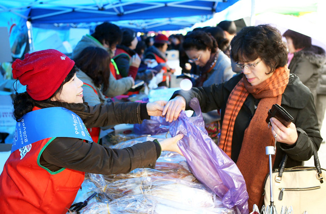 ▲ 과메기와 물회, 오징어 무료 시식코너에서 서울시민들이 눈이 내리는 가운데 제철을 맞은 포항의 별미를 맛보고 있다.