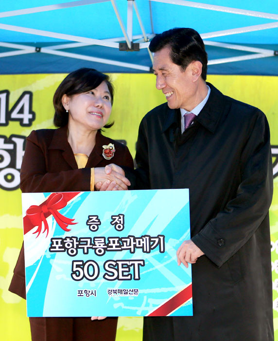▲ 우산을 쓴 시민들이 환한 표정으로 과메기, 검은돌장어, 가자미무침회 등 다양한 포항의 맛을 보기 위해 행사장을 구경하고 있다