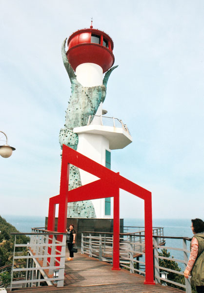▲ 강구항 다리목에 세워진 대게 발 조각 등대. 관광객이 그 밑에서 기념촬영을 하고 있다.