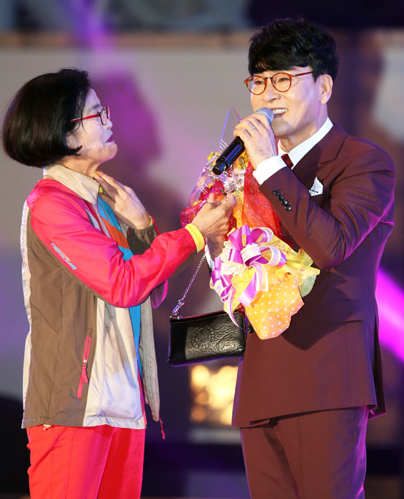 ▲ 인기가수 조항조가 꽃다발을 들고 무대에 올라온 열혈팬과 함께 히트곡을 선사하고 있다.