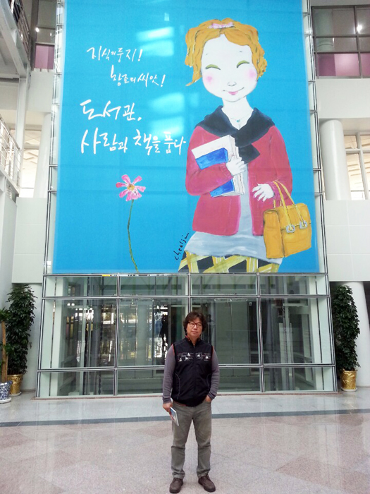 ▲ 이철진 작가가 포항 포은중앙도서관에서 열리는 `춘심이 도서관을 가다`전 전시장에서 포즈를 취하고 있다.