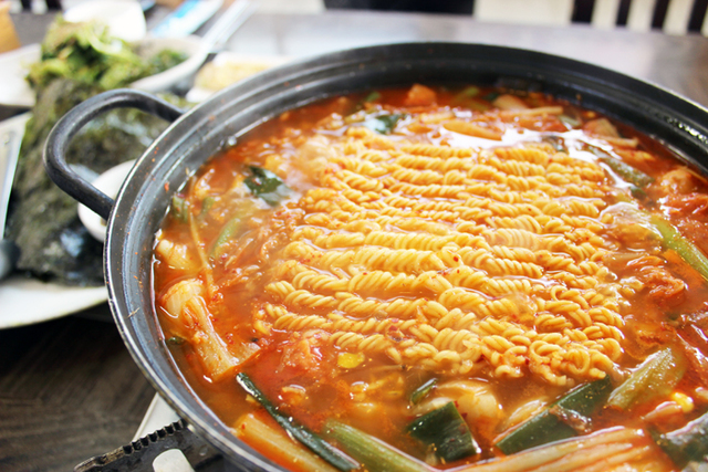 ▲ 흑돼지고기와 라면사리, 각종 채소 등 재료를 푸짐히 넣어 끓인 김치찌개.