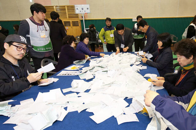 ▲ 제20대 총선이 치러진 13일 오후 포항시 북구 선거구의 개표가 진행된 흥해체육관에서 개표사무원들이 투표용지를 분류하고 있다.                                        /이용선기자