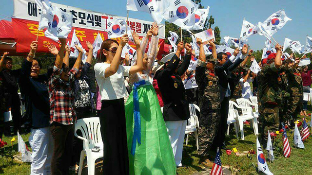 ▲ 재미 한인 교포들이 고국의 민족화합통일연대가 처음으로 기증한 태극기를 손에 들고 `만세삼창`을 하고 있다.