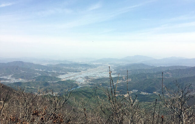 ▲ 여정봉에서 바라본 김천 대항면. 정상은 아직도 겨울인 듯 움도 틔우지 못했다. 그러나 산 아래는 융단을 깔아놓은 것 같다. 내가 봄 산을 좋아하는 이유는 저 연둣빛 때문이다. 이제 갓 돋아나기 시작한 새싹은 여리고 부드럽다. 연둣빛은 그런 것들이 내뿜는 빛깔이다. 산 아래에서는 이런 연둣빛이 지닌 다채로움을 감각할 수 없다. 그러나 정상에서는 층층이 쌓아올려진 빛깔들의 미세한 차이까지 느낄 수 있다. 그리하여 이 연약하고 유약한 빛깔이 얼마나 느리지만 신중한 걸음으로 산을 타고 오르는지를 볼 수 있다.
