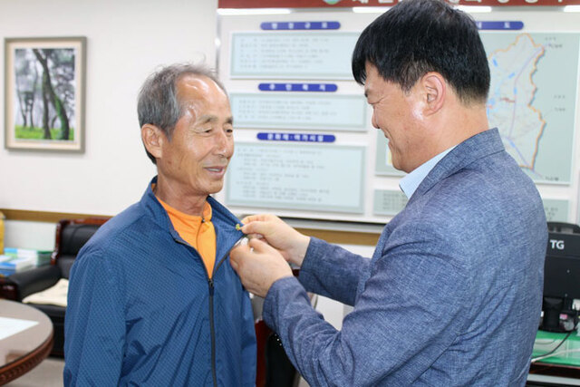 ▲ 예천읍 관계자가 한 기부자에게 `give 美人 배지`를 달아 주고 있다.                 /예천읍 제공