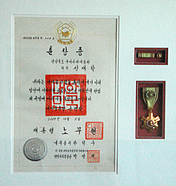 ▲ 2007년 고 노무현 대통령으로부터 받은 훈장. 신재학 회장은 대통령이 준 훈장이기에 소중하지만, 이 훈장은 새마을운동이 정치적 이념과 상관이 없다는 증표같아 더욱 소중하게 느껴진다고 했다.