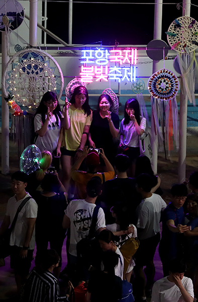 ▲ 화려한 불꽃쇼를 즐긴 시민과 관광객들이 불빛축제 조형물 앞에서 기념촬영을 하고 있다.