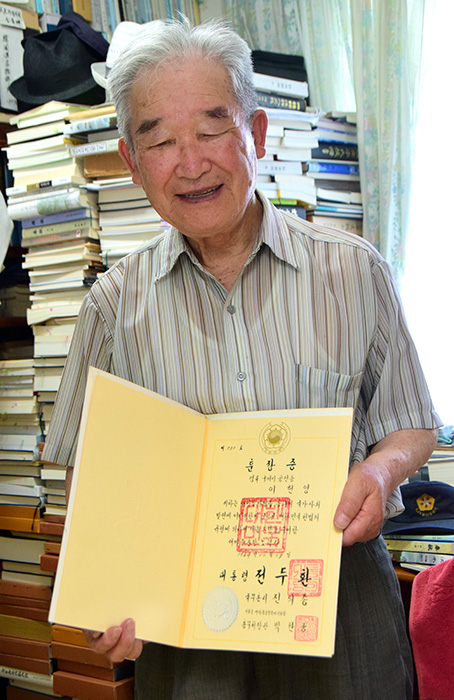 ▲ 이헌영 전 구미시새마을협의회장이 대통령 훈장증을 들고 포즈를 취하고 있다. /김락현기자 kimrh@kbmaeil.com