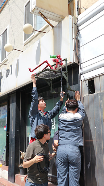 ▲ 꿈틀로 입주 예술가와 지역업체 직원들이 힘을 모아 간판을 제작하고 있다. /포항문화재단 제공