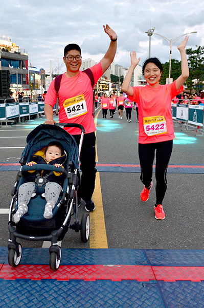 ▲ 아기와 함께 5km를 완주한 부부가 환한 표정으로 결승선을 통과하고 있다.