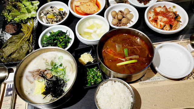 육개장 그릇 옆에 고추와 마늘 다진 것이 있다.
