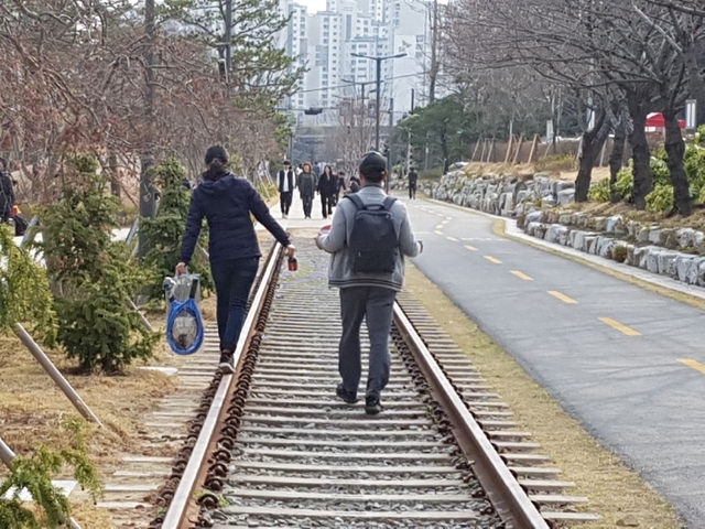 나들이객들이 철길로 걷고 있다.