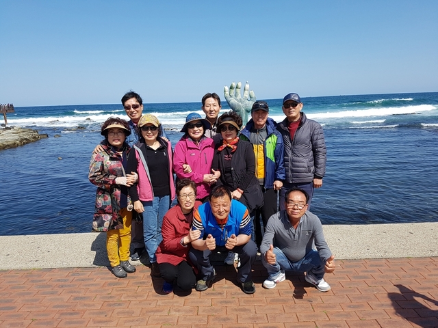 마산 매서초등학교 39회 동기들이 호미곶 상생의 손을 배경으로 기념촬영을 하고 있다.