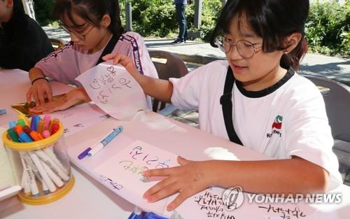 제주문화의 정수를 느낄 수 있는 탐라 문화제가 개막한 9일 오전 제주시 산지천 탐라문화광장 일대 행사장에서 한글날을 맞아 어린이들을 대상으로 손글씨 체험 행사가 이뤄지고 있다. /연합뉴스