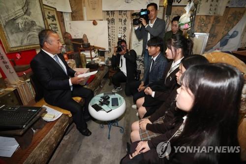 한글날인 9일 오전 고교생들이 경북 상주시 훈민정음 해례본 상주본(이하 상주본) 소장자 배익기 씨가 운영하는 골동품점에서 배 씨에게 상주본 반환 서명을 전달하고 있다. /연합뉴스