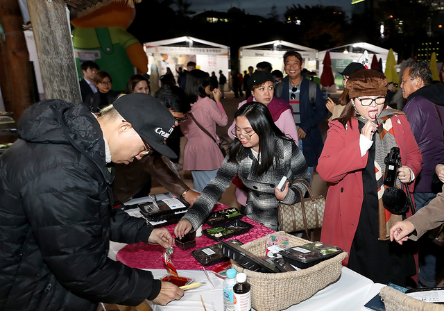한옥마을 원두막에 차려진 구룡포 과메기 홍보부스에서 관광객들이 과메기 시식을 하고 있다.