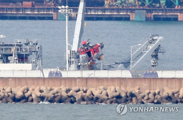 4일 포항신항 해군부두에 세워진 청해진함에서 해군 측이 독도 해역에서 인양한 소방헬기 동체를 특수차로 옮기고 있다.