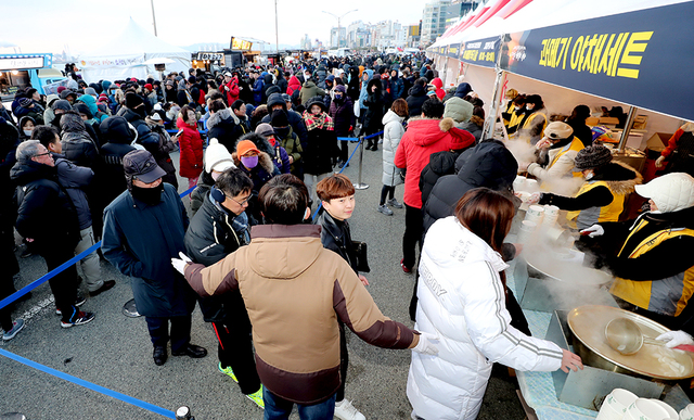 경북매일신문이 주관한 포항 구룡포 과메기와 함께하는 영일대 해맞이 행사 현장에서 나눠주는 떡국을 맛보려는 해맞이객들이 장사진을 이루고 있다.  /이용선기자 photokid@kbmaeil.com