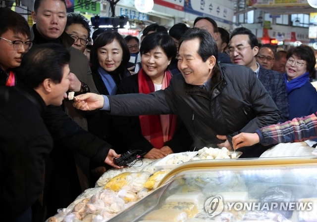 정세균 국무총리가 주말인 18일 서울 중랑구 우림골목시장을 방문해 물가를 점검하며 일행과 함께 떡을 시식하고 있다.
