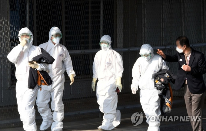 검역 관계자들이 31일 서울 김포국제공항에서 정부 전세기편으로 김포공항에 도착한 우한 교민과 유학생들의 진단을 마친 후 이동하고 있다.