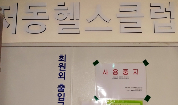헬스장 입구에 사용중지 표지가 붙었다.