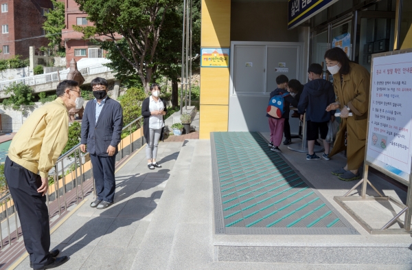 최영택교육장이 학교 입구에서 학생들과 학부형을 맞이하고 있다.