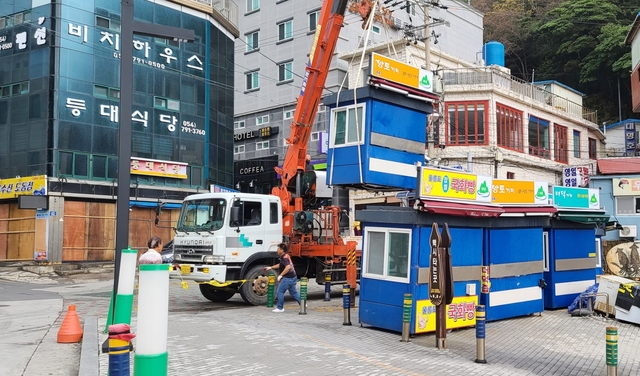 울릉도관문 도동항 해변공원 이동식 상점들을 철수하고 있다.