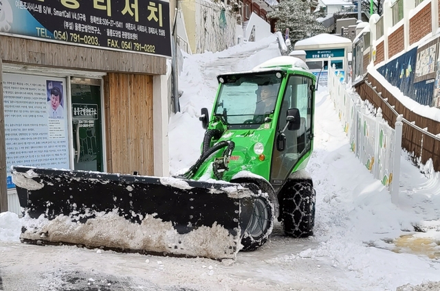 소형제설차량은 골목길과 대형차량이 지나간 가장 자리를 치우고 있다.