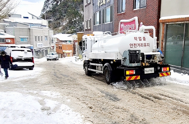 살수차가 바닷물을 뿌려 얼거나 조금 쌓인 눈을 녹이고 있다.