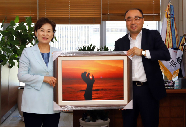 국토교통부 김현미 전 장관에게 포항 호미곶 일출 사진을 선물하는 최병욱 위원장.