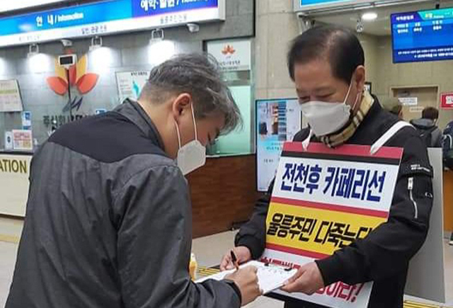 남진복 경북도의원(울릉)이 포항 여객선 터미널에서 1인 시위 및 서명을 받고 있다.