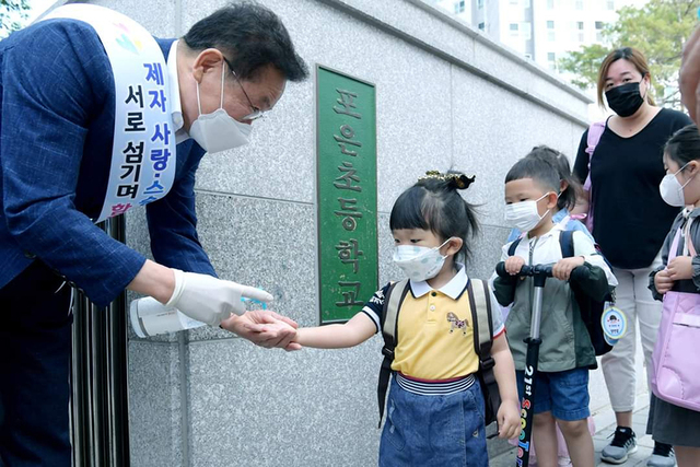 최기문 영천시장이 포은초등학교 교문에서 등교하는 어린이들의 코로나19 방역을 돕고 있다.