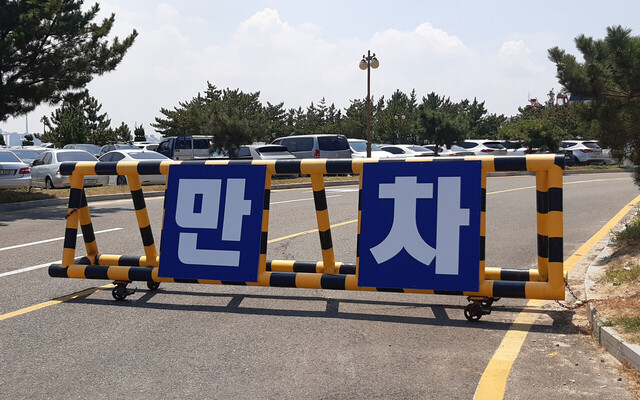 포항울릉도여객선 터미널 진입 도로를 사이에 두고 텅빈 오른쪽과 달리  만차가 표시된 왼쪽 승용차 주차장.