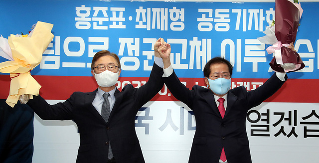 국민의힘 홍준표 대선 경선 후보(오른쪽)와 최재형 전 감사원장이 17일 오전 서울 여의도 홍준표 캠프 사무실에서 열린 최 전 감사원장 영입 행사에서 꽃다발을 들고 포즈를 취하고 있다.  /연합뉴스