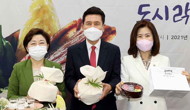 구룡포 출신인 김미애 의원(오른쪽)이 김정재 의원, 이강덕 포항시장과 함께 구룡포 과메기를 홍보하고 있다.  /사진=이용선기자