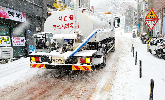 대형살수차에 바닷물을 싣고와 시내 도로에 뿌리고 있다.