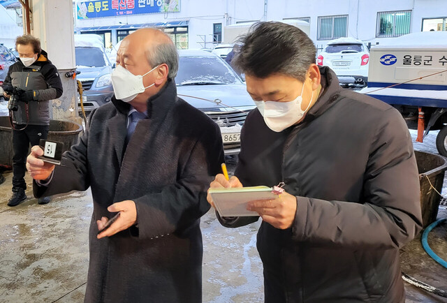 김형수 울릉군수협장(사진 왼쪽)이 경매사로 나서 오징어 초매를 하고 있다.