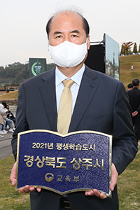 강영석 상주시장이 평생교육도시 지정 동판을 들고 기념촬영을 하고 있다.