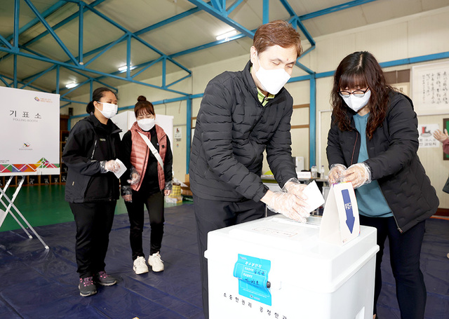포항시 남구 오천읍 제12투표소에서 시각장애인 김건형 씨가 투표 도우미와 함께 소중한 한 표를 행사하고 있다.