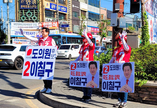 경북도의원 최고 득표율을 기록한 국민의힘 이칠구 당선자가 3일 오거리 교통섬에서 운동원들과 함께 당선 인사를 하고 있다.  /박동혁기자