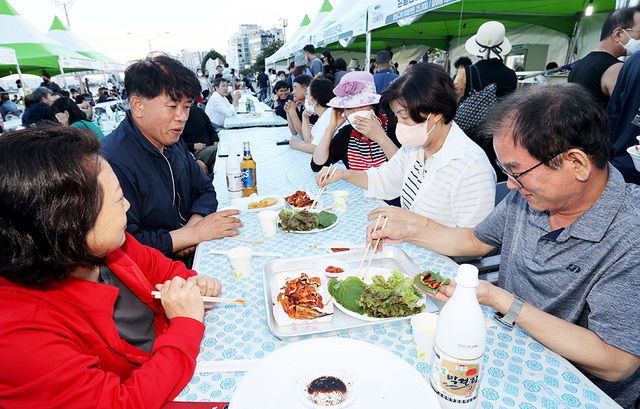 행사장을 찾은 시민들이 숯불에 구워진 검은돌장어를 맛보고 있다.