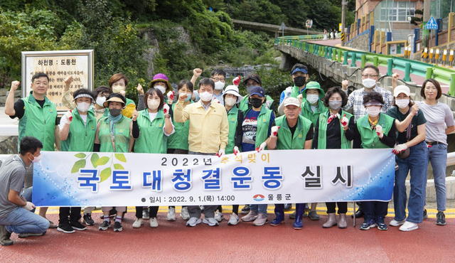 울릉도를 깨끗이 국도대청결운동에 참가한 남한권 울릉군수, 정석두 울릉새마을회장 및 새마을지도자 등 관계자들이 화이팅을 외치고 있다. /김두한 기자 