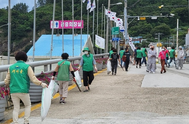 울릉군 새마을 부녀회원들이 도롯가 쓰레기를 치우고 있다..