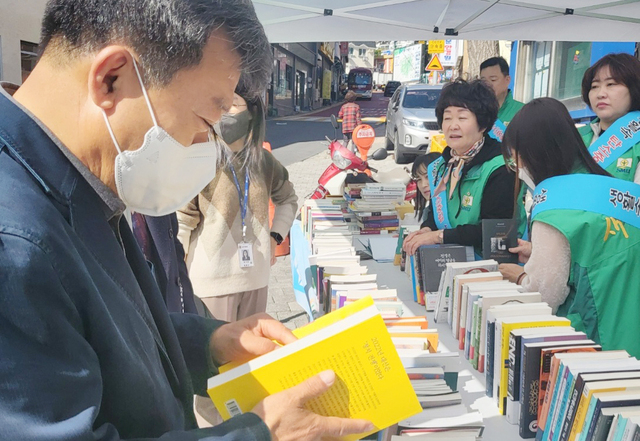남한권 울릉군수가 새마을문고 울릉군지부가 마련한 알뜰도서 교환시장을 방문 책을 고르고 있다 /김두한 기자