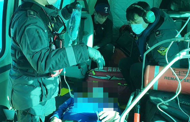 헬기 비행 중 응급구조사가 환자를 처치하고 있다 /동해해경청 제공