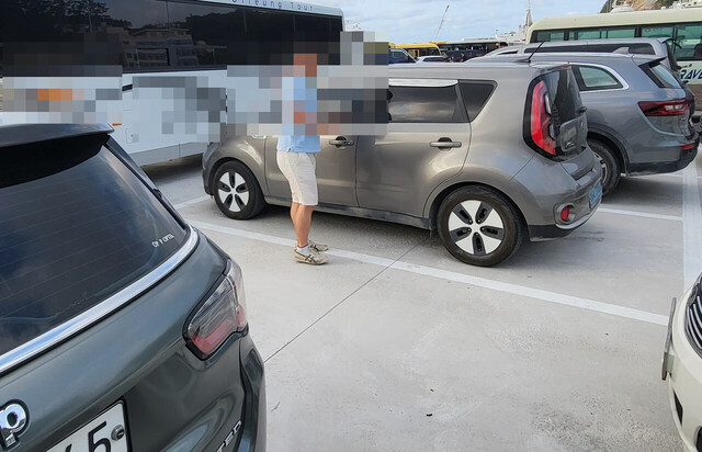 버스에 막혀 차를 빼내지 못하고 버스운전사를 찾고 있다.