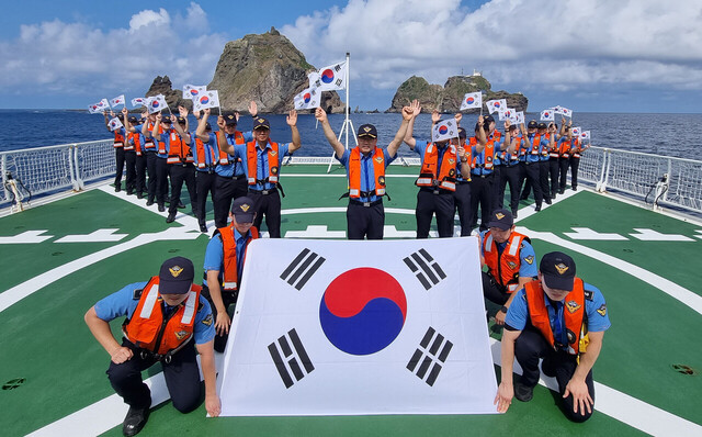 독도 배경으로 태극기를 들고있는 만세를 부르는 동해해경 모습/동해해경제공