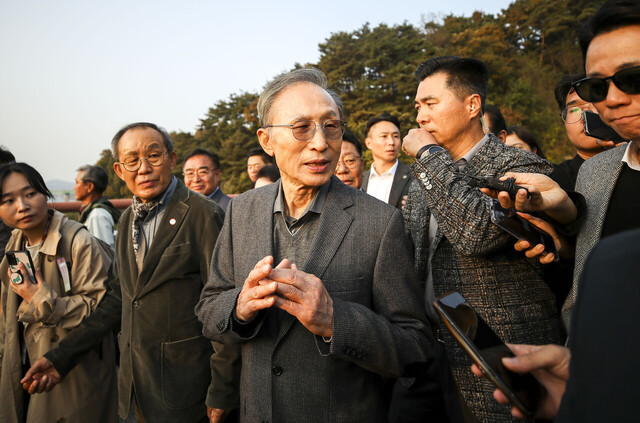 이명박 전 대통령이 25일 경기 여주시 한강문화관에서 열린 4대강 보 걷기 행사에서 '이포보, 여주보, 강천보를 지키는 모임' 관계자를 비롯한 지지자들과 강천보를 걸으며 취재진 질문에 답하고 있다. /연합뉴스